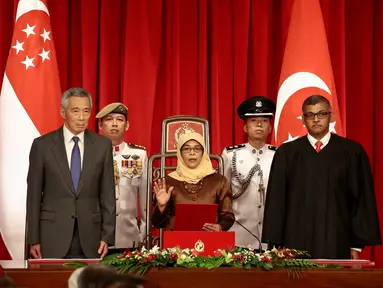 Halimah Yacob mengambil sumpah jabatan saat berdiri bersama PM Singapura, Lee Hsien Loong (kiri) dan Ketua Hakim Sundaresh Menon saat peresmian menjadi Presiden Singapura di Istana Kepresidenan Singapura, (14/9). (Wallace Woon/Pool Photo via AP)