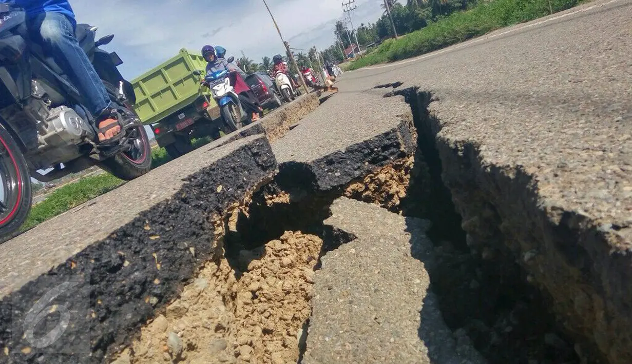 Kondisi jalan retak di Kabupaten Pidie Jaya, Aceh, Kamis (8/12). Gempa berkekuatan 6,5 SR pada Rabu pagi menyebabkan sejumlah ruas jalan retak dan mengalami kerusakan. (Liputan6.com/Angga Yuniar)