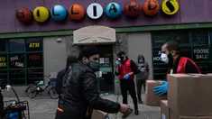 Ahmad Soliman (kiri) dan sukarelawan Muslim Giving Back lainnya membagikan kotak makanan kepada keluarga yang membutuhkan di lingkungan Bay Ridge, Brooklyn, New York, pada 29 April 2020. Kegiatan komunitas Muslim tersebut berlangsung selama Ramadan. (AP Photo/Wong Maye-E)