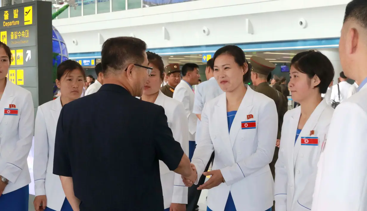 Atlet Korea Utara yang dikepalai Wakil Menteri Olahraga Korea Utara, Won Kil U bersiap meninggalkan bandara internasional Pyongyang, Korut (10/8). Korut akan berpartisipasi dalam Asian Games 2018 di Jakarta dan Palembang, Indonesia. (AP Photo/Cha Song Ho)