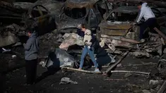 Seorang wanita menggendong anjingnya saat berjalan melewati mobil-mobil yang terbakar sehari setelah serangan udara Israel di Beirut, Lebanon, Kamis 9 April 2026. Israel terus melancarkan serangan besar-besaran terhadap Lebanon. (AP Photo/Emilio Morenatti)