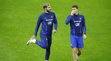 Bek Fance Theo Hernandez (Kiri) berbicara dengan Benjamin Pavard selama sesi latihan menjelang lanjutan Kualifikasi Euro 2024 Grup B, di stadion Johan Cruijff, di Amsterdam, Kamis (12/10/2023). (Kenzo TRIBOUILLARD / AFP)