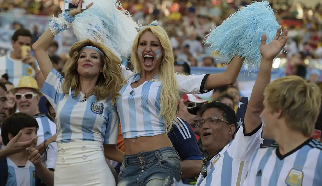 Dua suporter cantik Argentina terlihat bersemangat mendukung tim kesayangan di laga final piala dunia melawan Jerman, Senin (14/7/14). (AFP PHOTO/JUAN MABROMATA)