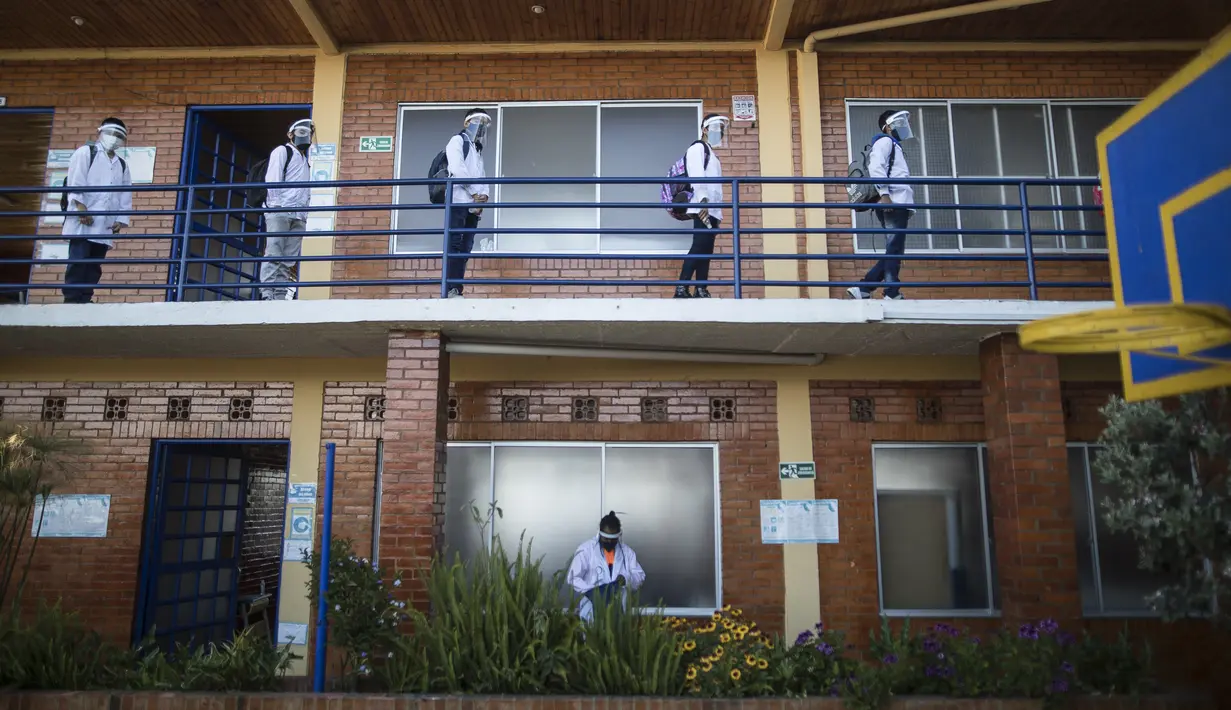 Siswa dengan menjaga jarak memasuki ruang kelas pada hari pertama kembali ke kelas tatap muka sejak Maret 2020 di Liceo Lunita, sebuah sekolah swasta di Chia, pinggiran Bogota, Kolombia, Jumat (5/2/2021). Sejauh ini Kolombia melaporkan lebih dari 2,13 juta kasus Covid-19. (AP Photo/Ivan Valencia)