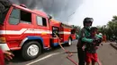 Pengemudi ojek online menenangkan seorang anak saat kebakaran melanda sebuah gudang di Jalan Kampung Bandan, Ancol, Jakarta Utara, Kamis (5/7). (Kapanlagi.com/Budy Santoso)