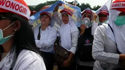 Sejumlah wanita yang berprofesi sebagai perawat honorer melakukan unjuk rasa di depan Gedung DPR, Jakarta, Kamis (16/3). Mereka mengenakan pakaian putih tersebut tergabung dalam Persatuan Perawat Nasional Indonesia (PPNI). (Liputan6.com/Johan Tallo)