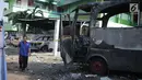 Seorang pria melintas dekat bangkai sebuah bus yang terbakar di sekitar asrama Brimob Jalan KS Tubun, Petamburan, Jakarta Barat, Rabu (22/5/2019). Diketahui kerusuhan terjadi di lokasi tersebut, buntut demo depan gedung Bawaslu yang berujung ricuh. (Liputan6.com/Faizal Fanani)