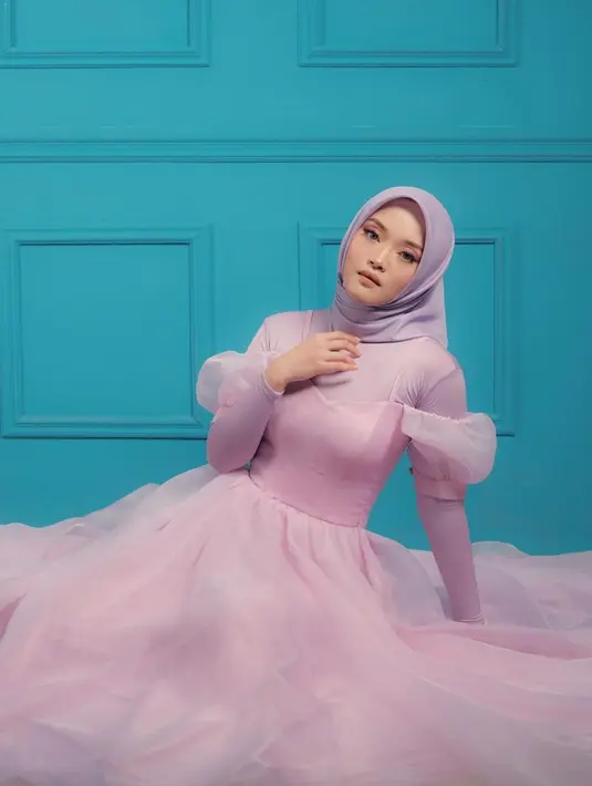 Selain dikenal sebagai penyanyi, Putri Delina juga piawai berpose di depan kamera. Ketika menjalani sebuah pemotretan, ia tampil totalitas bak seorang model hijab. Adik Rizky Febian ini tampil menawan dengan gaun berwarna ungu.(Liputan6.com/IG/@putridelinaa)