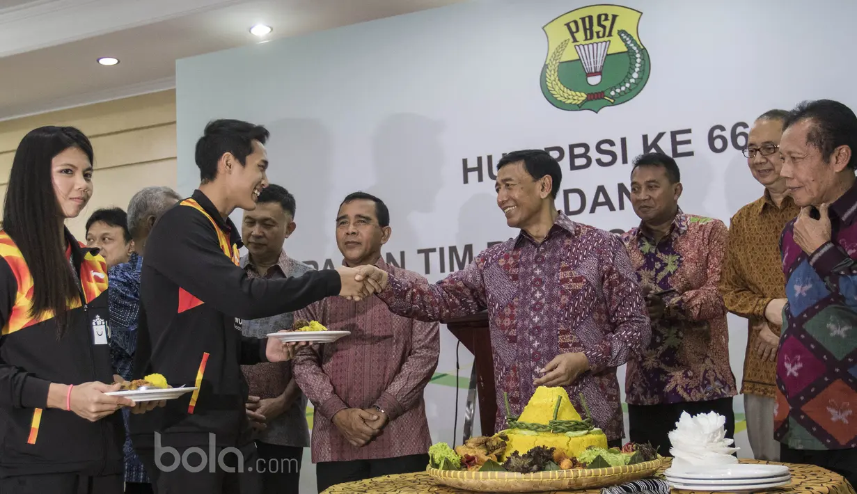 Ketua Umum PBSI, Wiranto, memberikan tumpeng pertama kepada Jonatan Christie dan Greysia Polii saat perayaan ulang tahun PBSI di Kantor PBSI Cipayung, Jakarta, Sabtu (6/5/2017). (Bola.com/Vitalis Yogi Trisna)