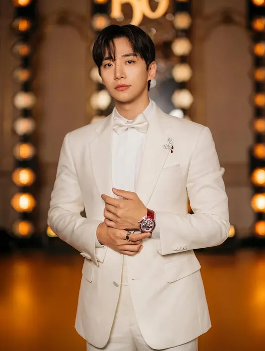 Penampilan serba putih dari Lee Jun Ho. Ia memadukan kemeja, dasi kupu-kupu, jas, dan celana panjang putih yang serasi. Lalu tak lupa ia menambahkan bros, cincin, dan jam tangan mewah. [Foto: Instagram/le2jh]