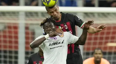 Bek AC Milan Malick Thiaw melompat untuk mengejar bola dengan penyerang Cremonese Felix Afena-Gyan pada laga pekan ke-33 Serie A 2022-2023 di San Siro, Kamis (4/5/2023). (AP Photo/Antonio Calanni)