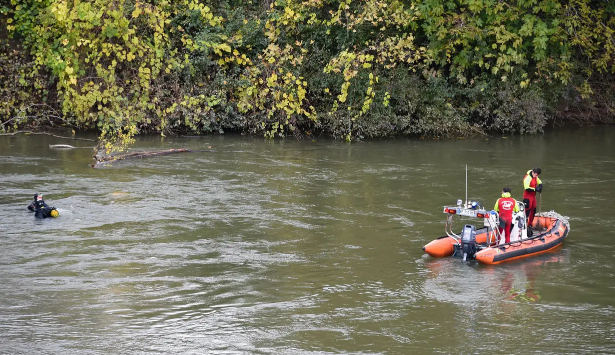 Tim penyelamat menyelam di  sungai Tarm, dekat jembatan gantung yang ambruk di Prancis, Selasa (18/11/2019). Insiden terjadi pada pukul 08.00 waktu setempat setelah kabel penghubung jembatan tersebut putus dan menyebabkan bagian jembatan ambruk. (ERIC CABANIS/AFP)