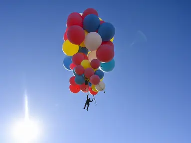 David Blaine terbang dengan memegang balon helium saat melakukan aksi "Ascension" di Page, Arizona, Amerika Serikat, Rabu (2/9/2020). David Blaine berhasil melakukan aksi ekstrem tersebut dengan terbang setinggi 7.600 meter. (David Becker/GETTY IMAGES NORTH AMERICA/Getty Images via AFP)