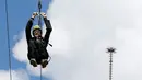 Seorang pengunjung meluncur dari Menara Eiffel di Paris dengan menggunakan peralatan flying fox, 5 Juni 2017. Kesempatan ini dibuka untuk umum jelang turnamen tenis French Open agar dapat merasakan bagaimana kecepatan bola tenis (FRANCOIS GUILLOT/AFP)