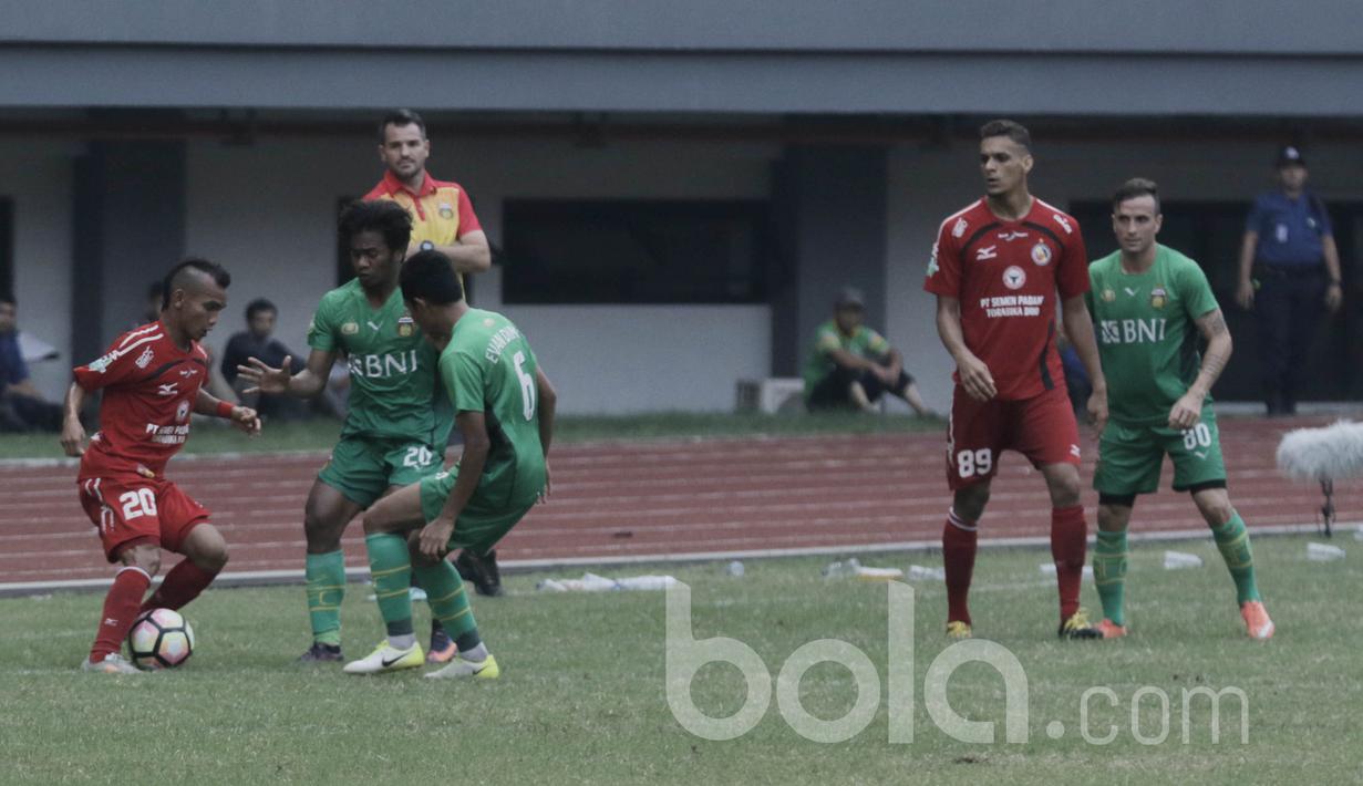 Pemain Semen Padang, Riko Simanjuntak, berusaha melewati pemain Bhayangkara FC pada laga lanjutan Liga 1 Indonesia di Stadion Patriot, Bekasi, Sabtu (20/05/2017). Bhayangkara FC menang 1-0. (Bola.com/M Iqbal Ichsan)