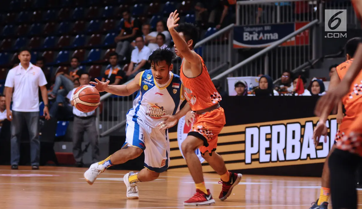 Pebasket Satria Muda Pertamina, Audy B Arizanugra mencoba lolos dari kawalan pemain NSH Jakarta pada Perbasi Cup 2017 di Britama Arena, Jakarta, Rabu (8/11). Satria Muda Pertamina unggul 83-67. (Liputan6.com/Helmi Fithriansyah)