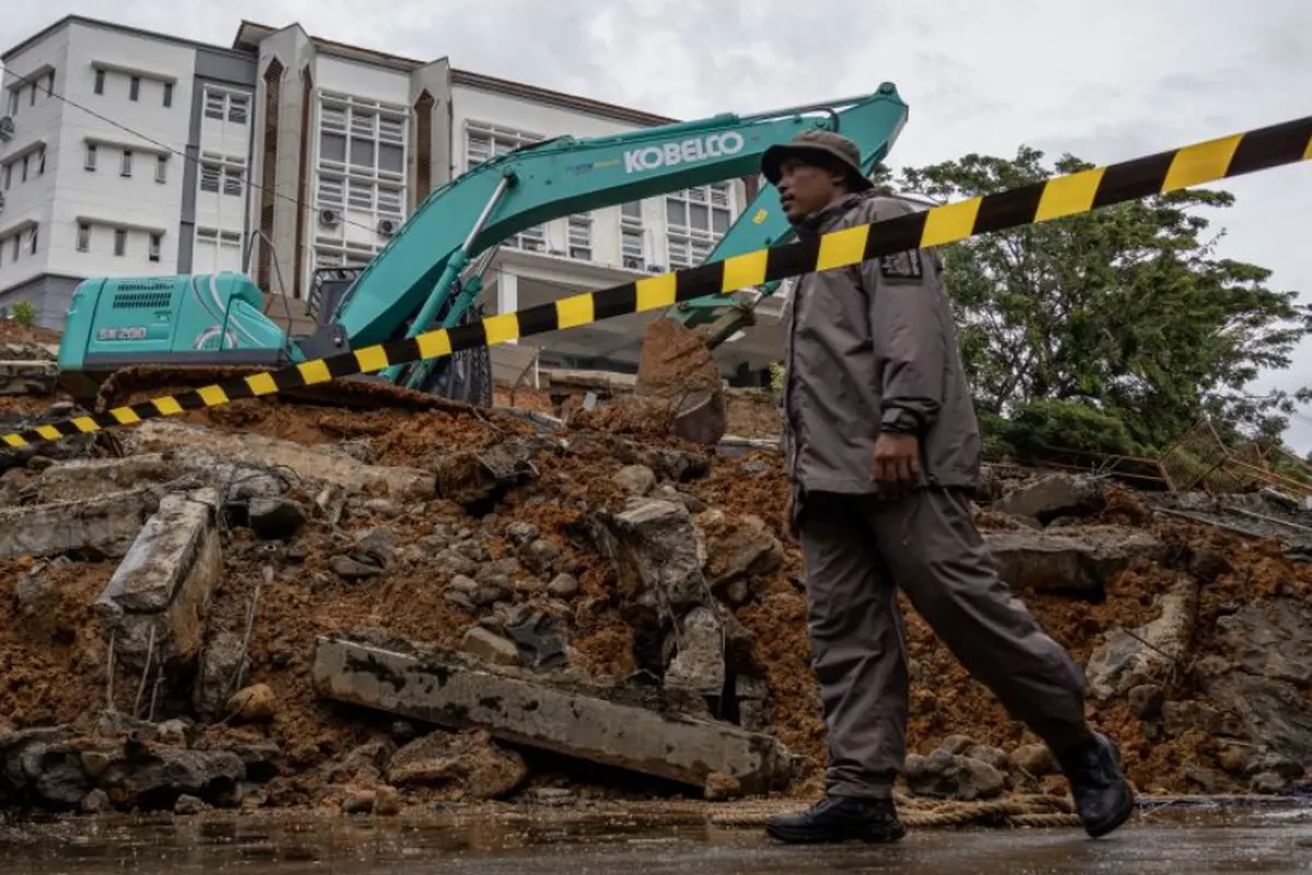 Satu unit ekskavator membersihkan tumpukan material longsor di UIN Imam Bonjol Padang, Sumatera Barat, Selasa 25 November 2025.