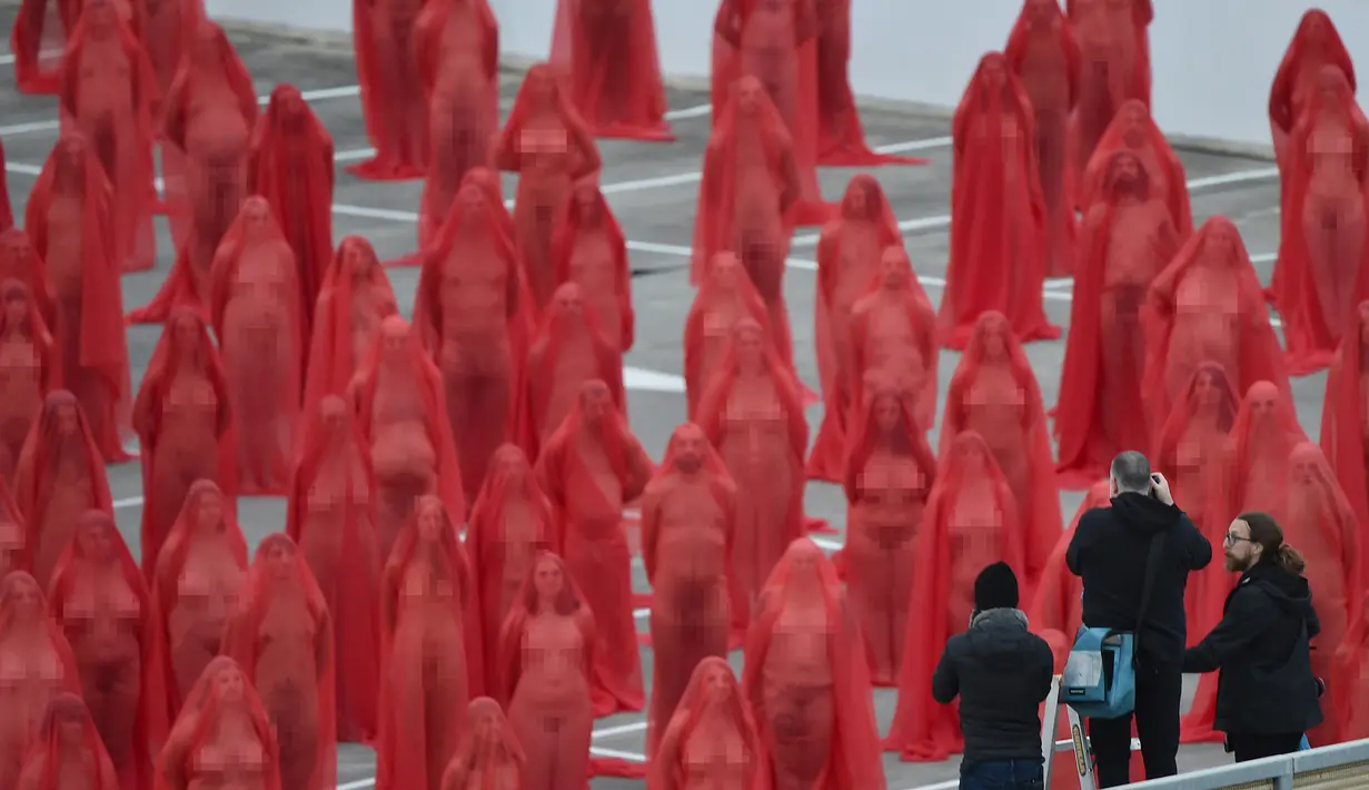 Fotografer Spencer Tunick (tengah) saat membuat karyanya di atap sebuah supermarket di Melbourne (9/7). Tunick dikenal kerap membuat foto bugil massal sebagai bagian dari karya seni untuk memprotes sejumlah isu global. (AFP Photo/Paul Crock)