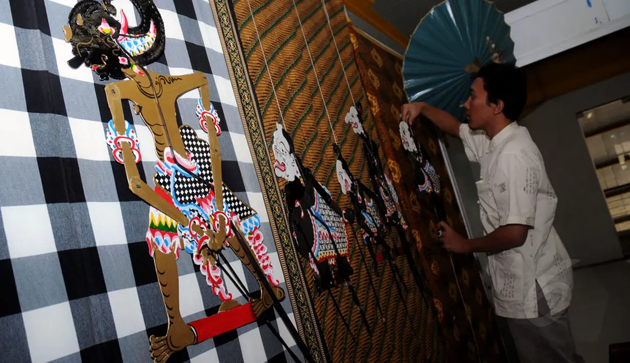Salah satu peserta menyiapkan wayang yang akan dipamerkan dalam festival Wayang Goes To Campus 2014 di Balairung Universitas Indonesia, Depok, (24/9/2014). (Liputan6.com/Helmi Fithriansyah)