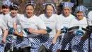 Para peserta melakukan pemanasan sebelum lomba lari dengan membawa pancake dalam lomba tahunan Pancake Trans-Atlantic, di kota Olney, Buckinghamshire, Inggris, Selasa (5/3). Peserta harus membolak-balikan pancake sambil tetap berlari. (AP/Frank Augstein)