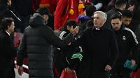 Pelatih Liverpool Jurgen Klopp (kiri) dan pelatih Real Madrid Carlo Ancelotti berjabat tangan usai pertandingan melawan Real Madrid pada pertandingan leg pertamababak 16 besar Liga Champions di stadion Anfield di Liverpool, Inggris, Rabu (22/2/2023). Liverpool kalah telak dari Madrid dengan skor 2-5. (AFP/Paul Ellis)