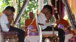 Tim sepak bola remaja Thailand yang berhasil diselamatkan dari dalam gua berdoa saat mengikuti ritual di Distrik Mae Sai, Chiang Rai, Kamis (19/7). Para korban mengaku kejadian tersebut mengajarkan mereka untuk tidak sembarangan. (AP Photo/Sakchai Lalit)