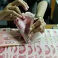 Petugas menghitung uang pecahan 100 Yuan, Jakarta, Kamis (13/8/2015). Biang kerok keterpurukan kurs rupiah dan sejumlah mata uang negara lain adalah kebijakan China yang sengaja melemahkan (devaluasi) mata uang Yuan. (Liputan6.com/Johan Tallo)