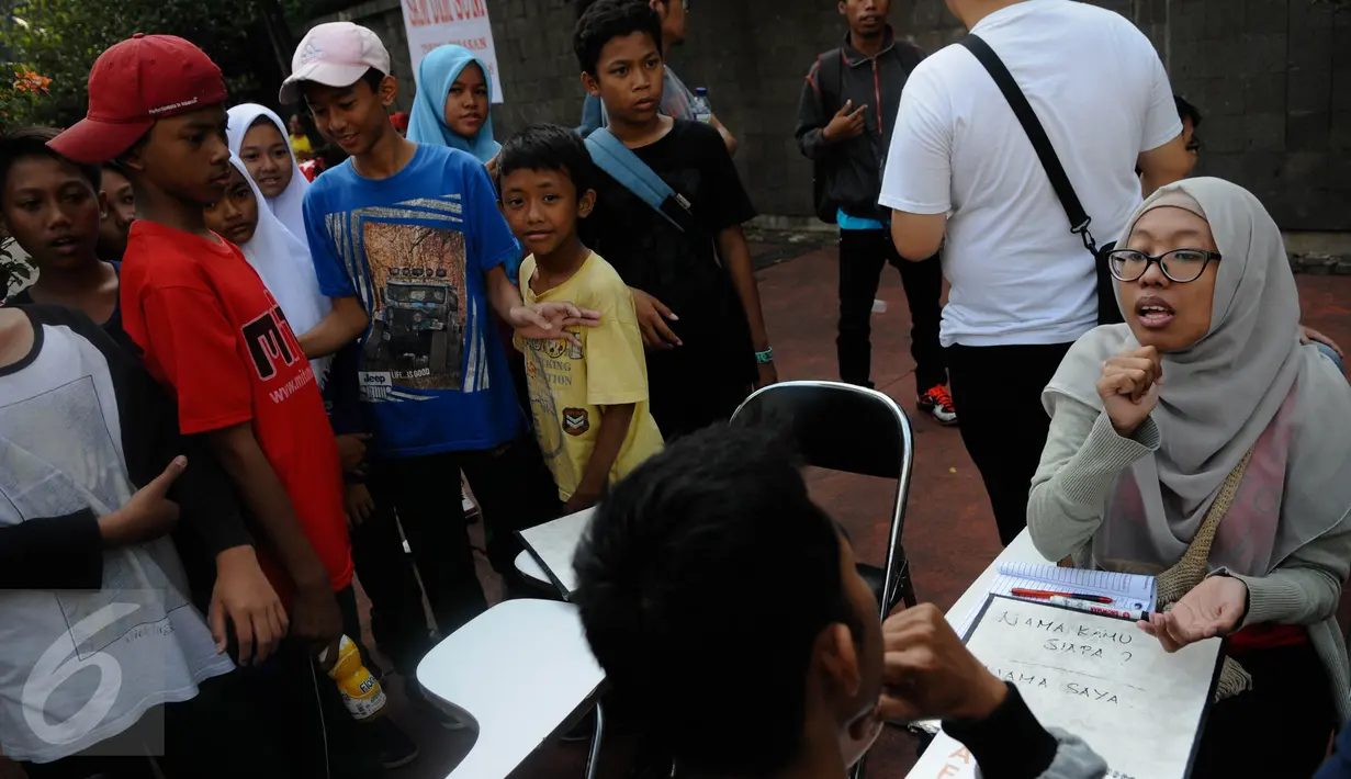 Sejumlah anak mengamati aksi sosialisasi bahasa isyarat di Car Free Day (CFD), Jakarta, Minggu (11/9). Sosialisasi belajar bahasa isyarat untuk mengkampanyekan penggunaan bahasa isyarat dalam dialog para penyandang tuna rungu. (Liputan6.com/Faizal Fanani)