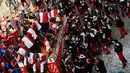 Keseruan festival "Battaglia delle Arance" (Perang Jeruk) di sebuah kota kecil di Provinsi Turin, Italia, Minggu (11/2). Penonton yang mengikuti festival ini menggunakan topi merah terang untuk membedakan dengan lainnya. (MIGUEL MEDINA/AFP)