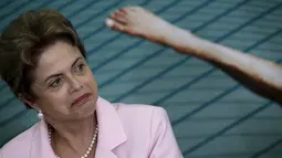  Presiden Brasil Dilma Rousseff saat berbicara kepa media soal krisis ekonomi an politik di Brasil. (27/8/2015). Ekspresi Presiden tampak murung disandingkan dengan sebuah foto kaki dibelakangnya. (REUTERS/Ueslei Marcelino)