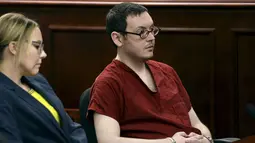 Terdakwa penembak di bioskop Colorado, James Holmes didampingi pengacaranya mengikuti sidang di Centennial, Colorado, Rabu (26/8). James dijatuhi hukuman penjara seumur hidup tanpa pembebasan bersyarat atas pembunuhan 12 orang.(REUTERS/RJ Sangosti/Pool)