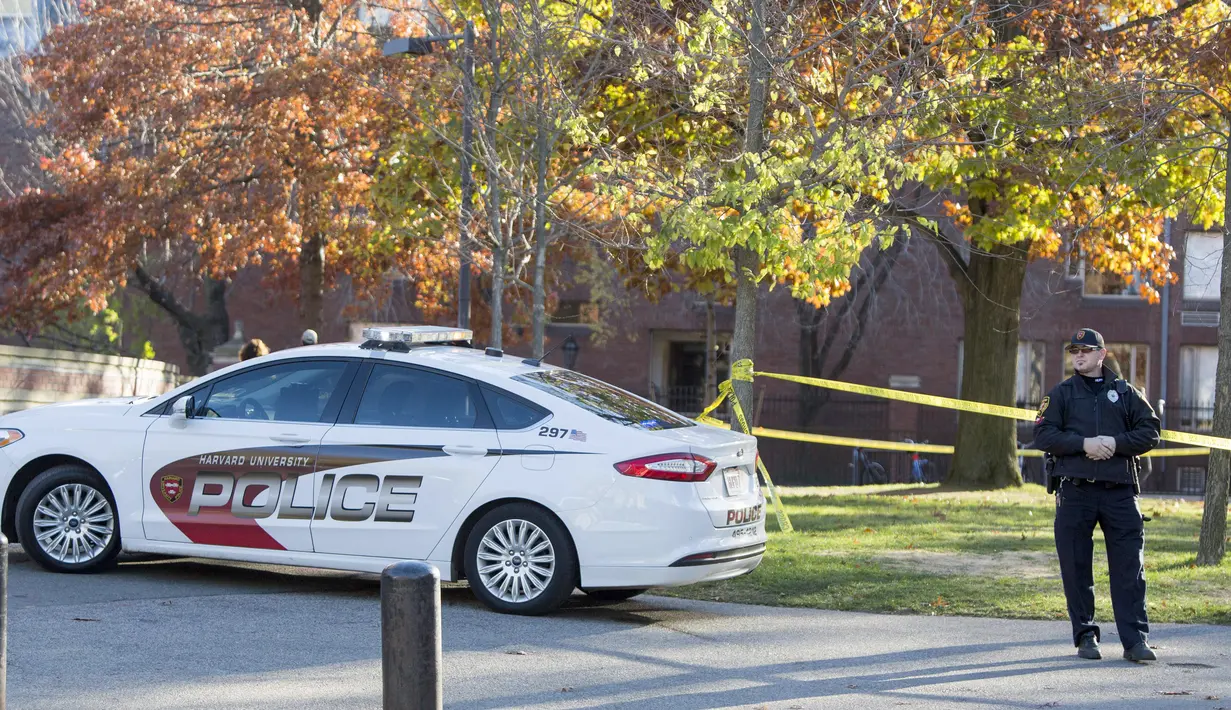 Petugas melakukan penjagaan ke area menuju Universitas Harvard menyusul ancaman bom di gedung yang berlokasi di Cambridge, Senin (16/11). Petugas mensterilkan empat gedung di universitas terkemuka di negara adidaya tersebut. (Scott Eisen/Getty Images/AFP)
