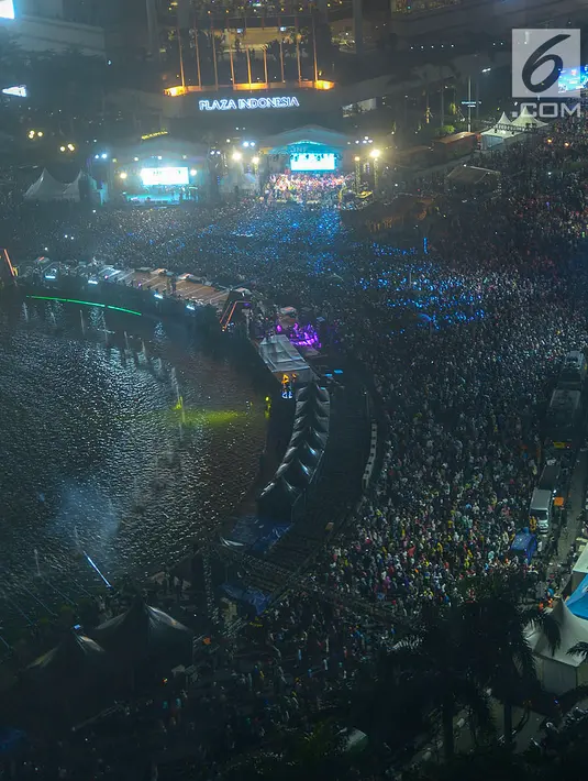 Ribuan warga memadati panggung hiburan pada malam puncak peringatan HUT DKI Jakarta ke-492 di Bundaran HI Jakarta, Sabtu, (22/6/2019). Rangkaian perayaan HUT DKI Jakarta diisi live mural Jakarta Anniversary, bazar kreatif, video mapping hingga festival musik. (merdeka.com/Imam Bukhori)