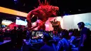 Di bawah patung raksasa Goliath, para pengunjung memainkan video game baru "Evolve" yang ikut dipamerkan dalam Electronic Entertainment Expo (E3), di Los Angeles, Amerika Serikat, (10/6/2014). (REUTERS/Kevork Djansezian)