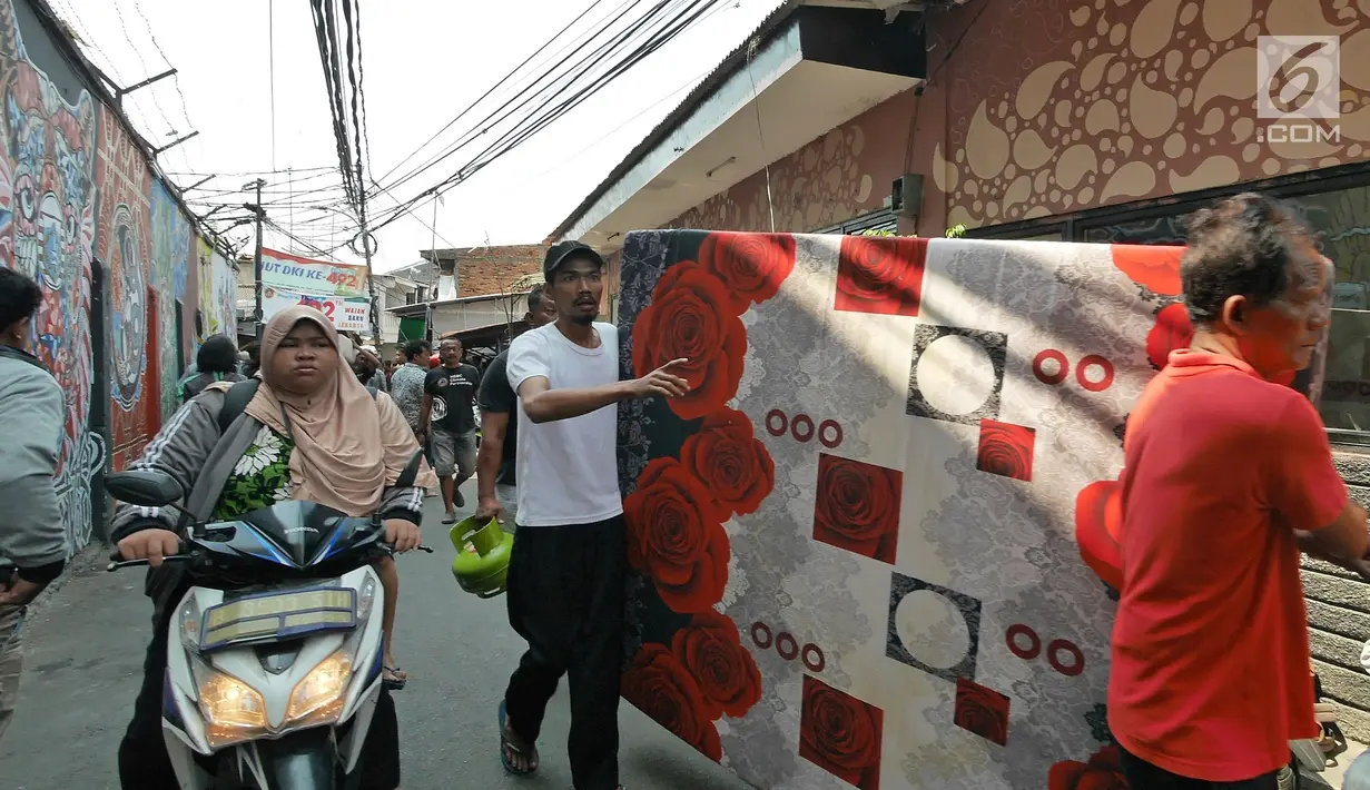 Warga berusaha menyelamatkan harta benda mereka ketika kebakaran melanda permukiman padat penduduk di Manggarai, Jakarta, Rabu (10/7/2019). Hingga saat ini sebanyak 28 unit mobil pemadam kebakaran dikerahkan di lokasi kejadian yang tak jauh dari Stasiun Kereta Api. (Liputan6.com/Herman Zakharia)