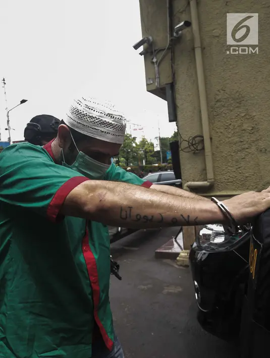 Artis Claudio Martinez dengan tangan di borgol usai rilis narkoba di Polres Jakarta Barat, Jumat (9/11). Claudio ditangkap dikediamannya di Pondok Kukusan Permai No 54 jalan KH Usman Rt 003/004 Kec Kukusan Kota Depok, Jabar. (Liputan6.com/Faizal Fanani)