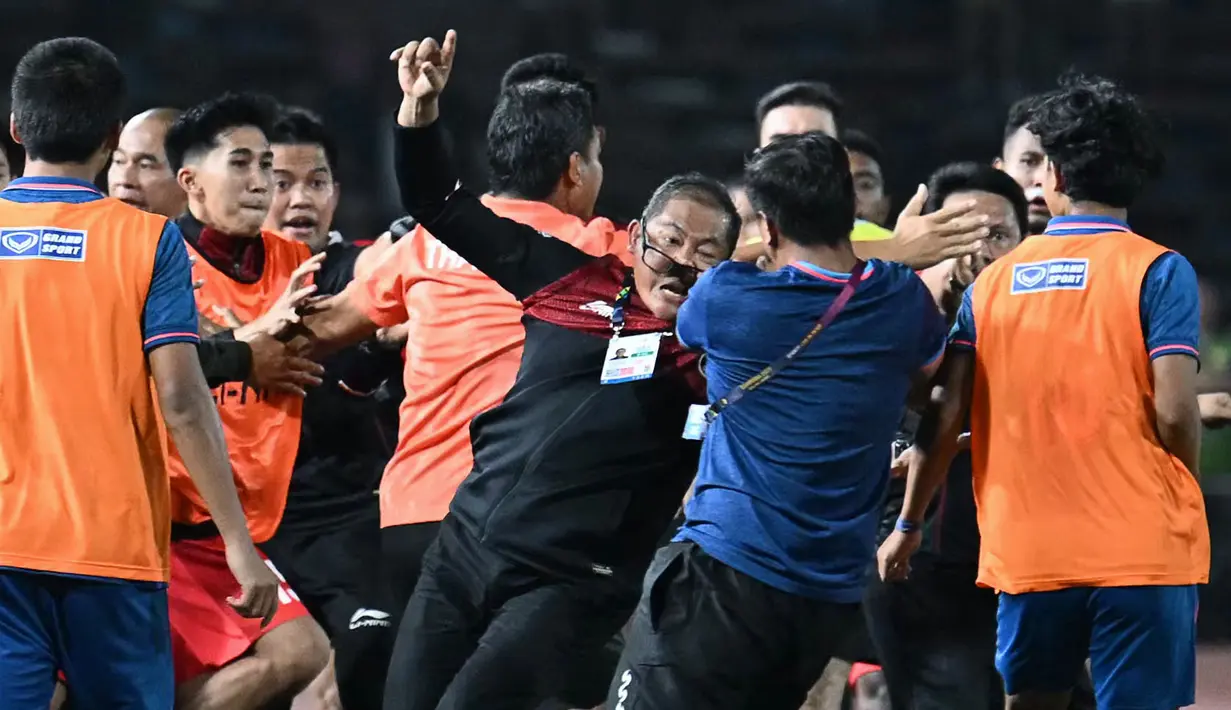 Manajer Timnas Indonesia U-22, Sumardji (tengah kiri) dikeroyok oleh official Timnas Thailand U-22 pada laga final SEA Games 2023 di Olympic Stadium, Phnom Penh, Kamboja, Selasa (16/05/2023). (AFP/Mohd Rasfan)