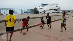 Seorang berusaha mengontrol bola saat bermain bola di pelataran Pelabuhan Kali Adem, Muara Angke, Jakarta, Rabu (4/1). Mereka memanfaatkan Pelabuhan Kali Adem sebagai arena bermain selama mengisi masa liburan sekolah. (Liputan6.com/Gempur M Surya)