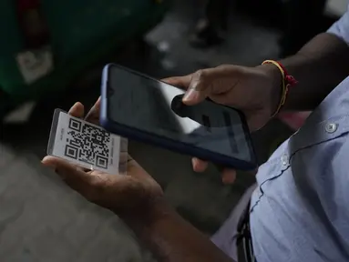 Seorang pekerja memindai kode QR sebelum mengisi bensin ke kendaraan di sebuah pompa bensin di Kolombo, Sri Lanka, Senin, 1 Agustus 2022. Sri Lanka memperkenalkan distribusi bahan bakar menggunakan kode QR pada hari Senin sebagai bagian dari penerapan kuota mingguan untuk pengendara. (AP Photo/Eranga Jayawardena)