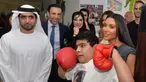 Artis reality TV, Kim Kardashian berpose dengan anak penyandang cacat di Rashid Media Centre, Dubai (16/1). Anak-anak penyandang cacat memberi sambutan khusus dengan tarian tradisional untuk Kim Kardashian. (AFP Photo And Rashid Media Center/Stringer) 