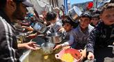 Orang-orang berebut untuk mendapatkan makanan hangat di kamp pengungsi Palestina, Nuseirat, Jalur Gaza Tengah pada Kamis 7 Mei 2026. Krisis kemanusiaan di Gaza per Mei 2026 mencapai titik kritis. (Eyad Baba/AFP)