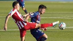 Pemain Atletico Madrid, Santiago Arias, berebut bola dengan pemain Levante, Enis Bardhi, pada laga La Liga di Stadion Camilo Cano, Selasa (23/6/2020). Atletico Madrid menang 1-0 atas Levante. (AFP/Jose Jordan)