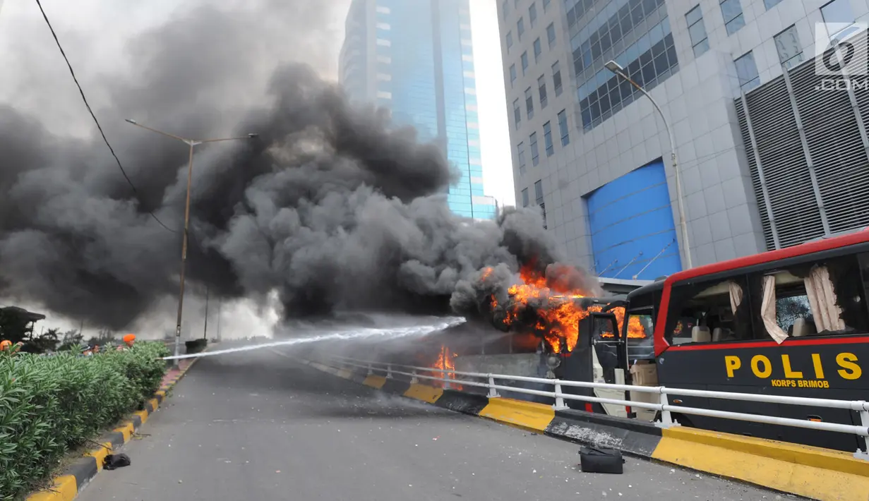Sejumlah anggota TNI memadamkan api yang membakar dua unit bus polisi di dekat Flyover Slipi, Palmerah, Jakarta Barat, Rabu (22/5/2019). Anggota terus berusaha melakukan pendinginan mengunakan APAR agar api tak kembali menyala. (merdeka.com/Arie Basuki)