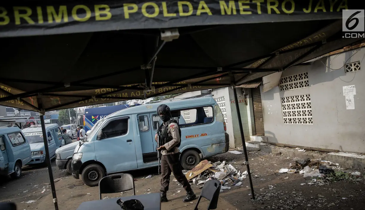Anggota Brimob mengecek kondisi dekat TKP bom bunuh diri di Halte TransJakarta Terminal Kampung Melayu, Kamis (26/5). Bom Kampung Melayu yang terjadi Rabu malam menewaskan tiga polisi dan dua orang yang diduga pelaku. (Liputan6.com/Faizal Fanani)