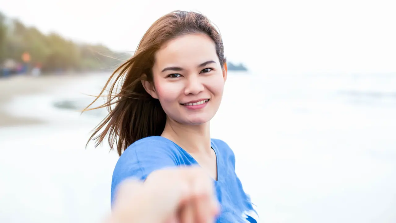 baju biru pantai memegang tangan pasangan bahagia