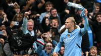 Striker Manchester City, Erling Haaland, berselebrasi setelah mencetak gol ke-100 untuk The Citizens dalam laga kontra Arsenal di Etihad Stadium, Minggu (22/9/2024). (Paul ELLIS / AFP)