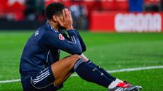 Pemain Real Madrid, Jude Bellingham, menutup wajahnya lantaran kecewa setelah bermain imbang 1-1 ketika menghadapi tuan rumah Girona pada laga lanjutan La Liga 2025/2026 di Montilivi, Senin (1/12/2025) dini hari WIB. (AP Photo/Joan Monfort)