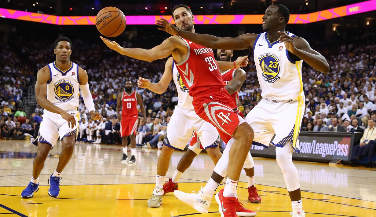 Pebasket Houston, Ryan Anderson #33 mencoba melewati adangan pebasket Warriors, Draymond Green #23 pada laga perdana NBA 2017 di Oracle Arena, Oakland, (17/10/2017).  Rockets menang 122-121.   Rockets menang 122-121. (Ezra Shaw/Getty Images/AFP)
