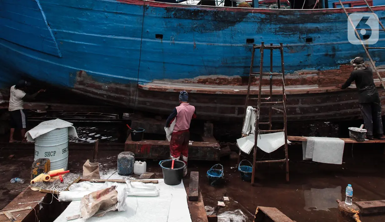 Buruh melakukan perbaikan kapal nelayan di Galangan kapal, Muara Angke, Jakarta, Minggu (23/12/2020). Dimasa pandemi Covid 19 aktivitas di galangan kapal tetap berjalan normal seperti biasa. (Liputan6.com/Angga Yuniar)