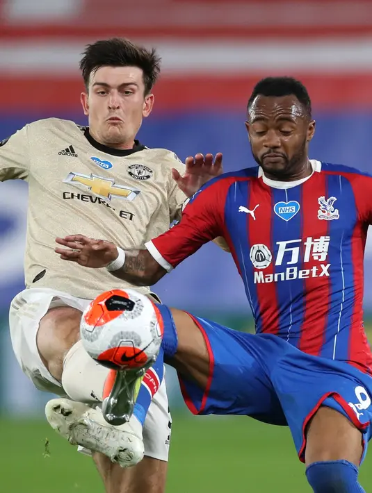 Bek Manchester United, Harry Maguire berebut bola dengan pemain Crystal Palace, Jordan Ayew dalam laga Liga Inggris pekan ke-36 di Selhurst Park, London, Kamis (16/7/2020).  MU meraih kemenangan di kandang Crystal Palace dengan skor 2-0. (AP Photo/ Peter Cziborra, Pool)